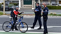 A cyclist is stopped by French police controlling the lockdown at La Baule in western France, Easter Monday, April 13, 2020.