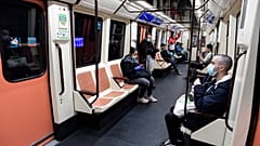 Commuters wearing face masks sit on a train at the Atocha Station in Madrid on April 13, 2020 as some companies resume operations amid the coronavirus lockdown. 