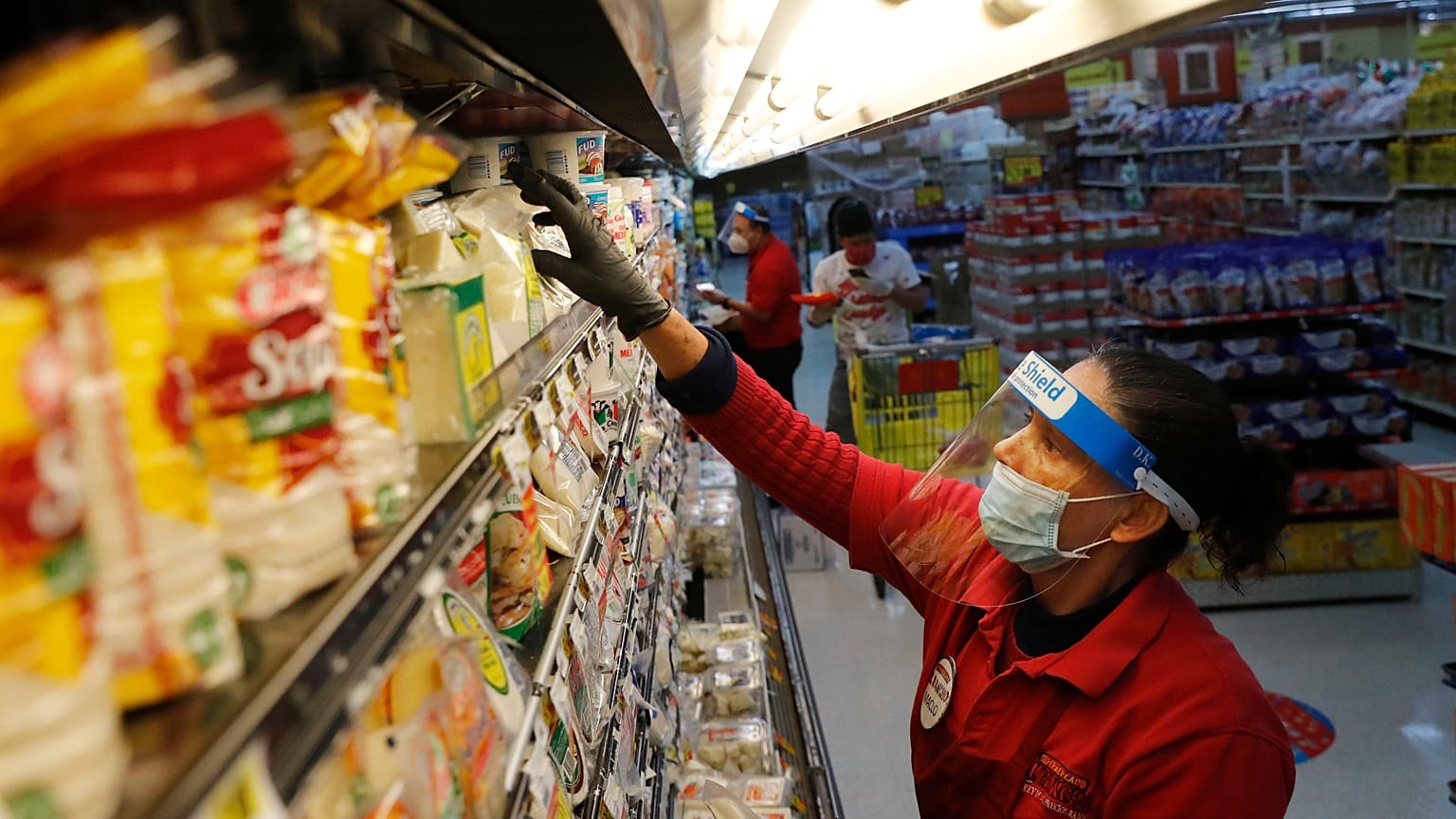Amid concerns of the spread of COVID-19, Maclola Orozco restocks food at El Rancho grocery store in Dallas, Monday, April 13, 2020.