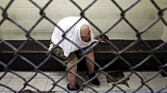 A U.S. veteran with post-traumatic stress, sits in a segregated holding pen at Chicago's Cook County