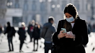 İtalya'nın Milano kentinde maske takan bir kadın/24 şubat