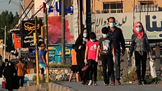Irak'ın başkenti Bağdat'ta halk, koronavirüs salgınına karşı maskeleriyle dolaşıyor