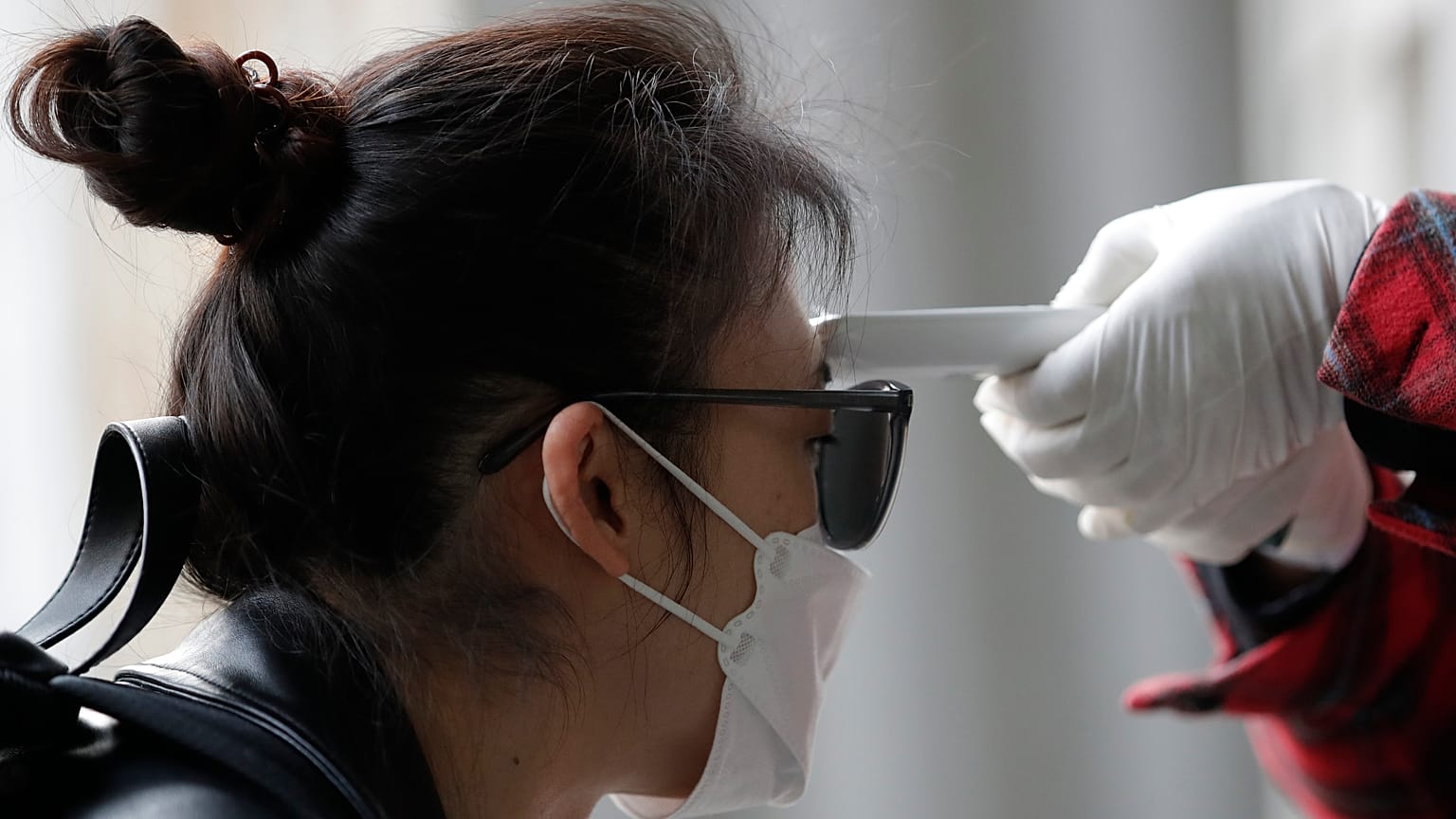 A voter has her temperature checked upon her arrival at a polling station in Seoul, South Korea, Wednesday, April 15, 2020.
