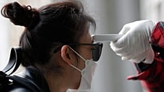 A voter has her temperature checked upon her arrival at a polling station in Seoul, South Korea, Wednesday, April 15, 2020.