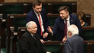 Jaroslaw Kaczynski,left, leader of the conservative ruling party Law and Justice, speaks with other members of his party in parliament in Warsaw, Poland, Friday April 3, 2020