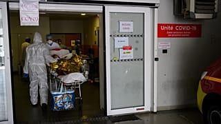A firefighter from the Marins-Pompiers of Marseille carries an old woman suspected of being infected with COVID-19 at the Timone Hospital in Marseille, on April 15, 2020