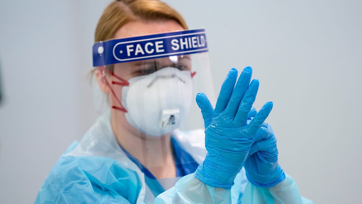 In this Thursday, April 16, 2020 photo, a member of staff receives training on how to put on and remove PPE