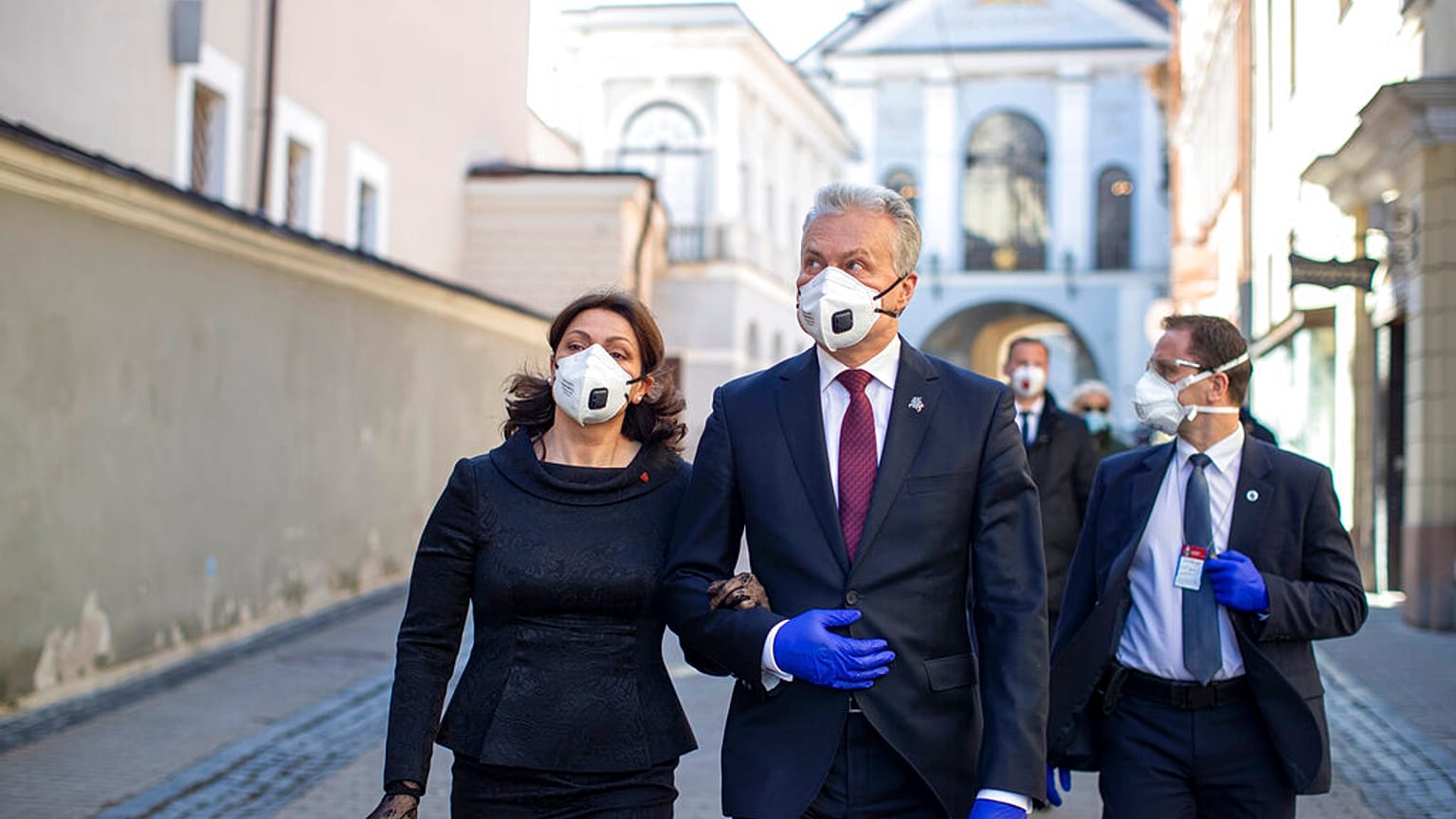 Lithuania's President Gitanas Nauseda and his wife Diana Nausediene, left, wearing face masks after leaving church in Vilnius