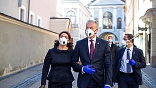 Lithuania's President Gitanas Nauseda and his wife Diana Nausediene, left, wearing face masks after leaving church in Vilnius