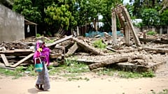 Mulher carrega criança ao colo em Moçambique