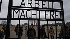 Visitors walk past the gate of the former Sachsenhausen concentration camp