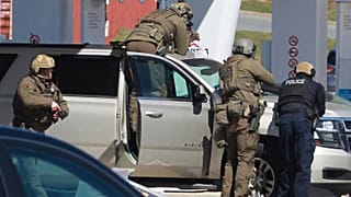 Royal Canadian Mounted Police officers surround a suspect at a gas station in Enfield, Nova Scotia, April 19, 2020