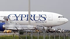 A Qatar Air Force fighter jets on the ground next of a Cyprus airways Airbus A330 