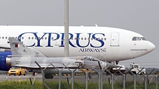 A Qatar Air Force fighter jets on the ground next of a Cyprus airways Airbus A330 