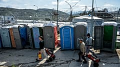 Migrants pull fire extinguishers in Moria refugee camp on the northeastern Aegean island of Lesbos, Greece, Monday, March 16, 2020