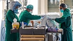 Medical workers tend to a patient at the Intensive Care Unit of the Tor Vergata Covid-4 hospital on April 21, 2020 in Rome