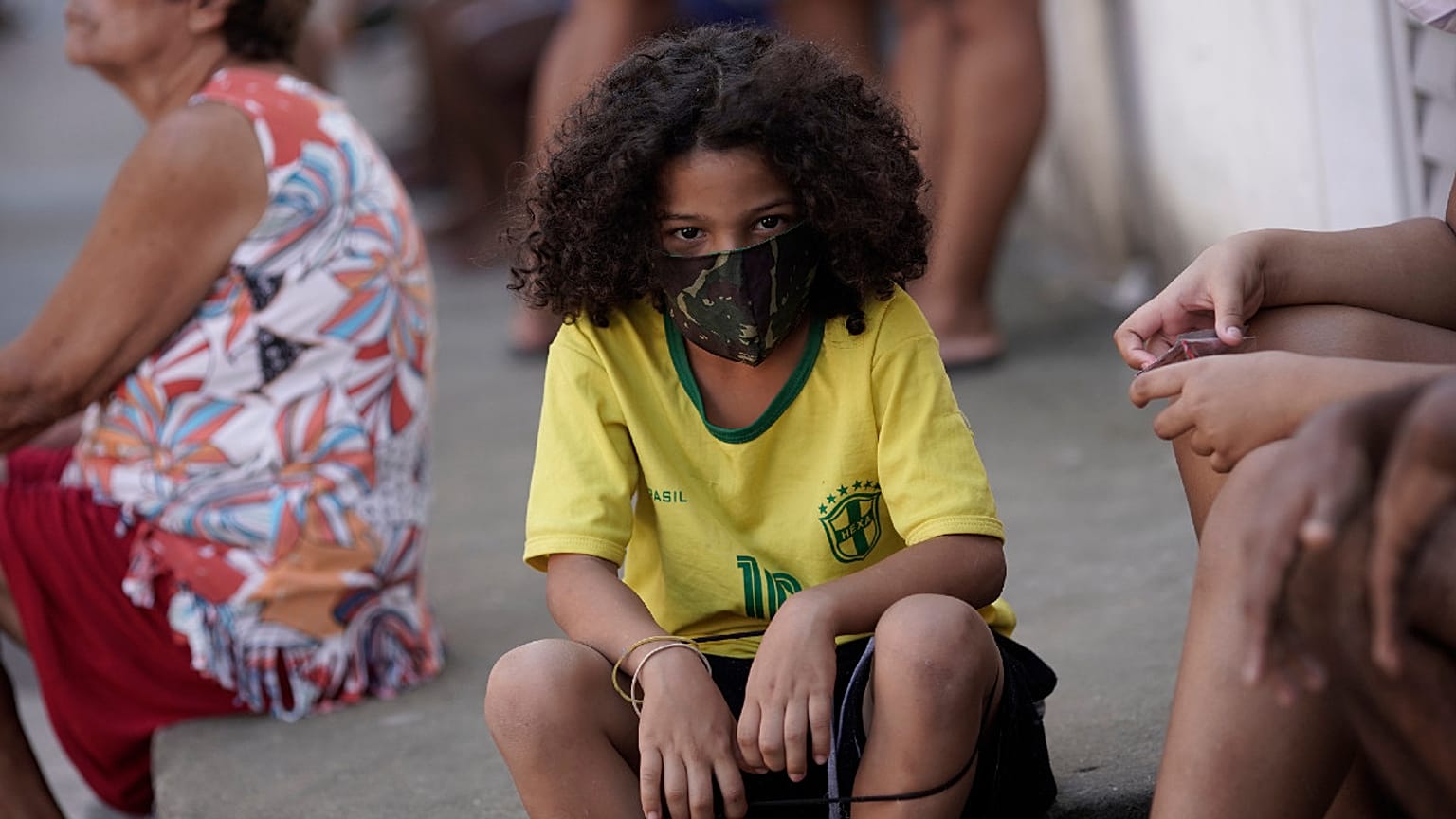 Uma criança protege-se da Covid-19 na favela Mandela, Rio de Janeiro