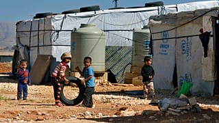 أمام مخيم للاجئين السوريين في بعلبك اللبنانية 