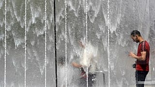 Un uomo si rinfresca vicino a una fontana a Milano, 28/06/2019