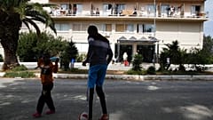Migrant boys play with a ball outside a hotel in Kranidi town, about 170 kilometers southwest of Athens, Tuesday, April 21, 2020