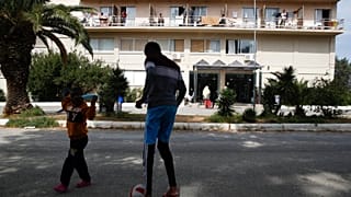 Migrant boys play with a ball outside a hotel in Kranidi town, about 170 kilometers southwest of Athens, Tuesday, April 21, 2020