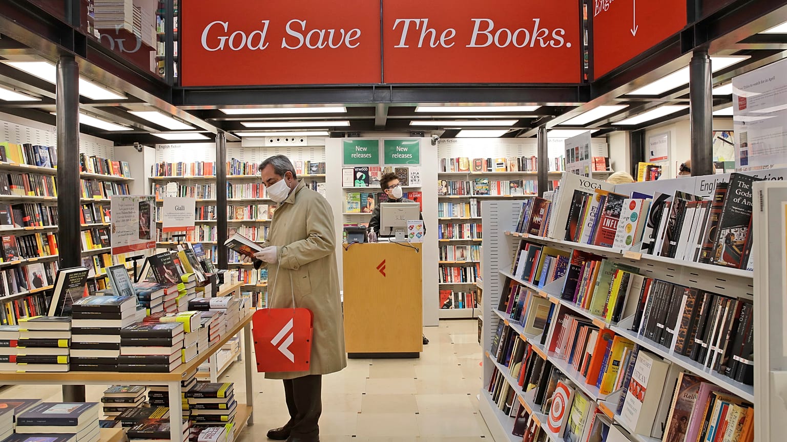 Un hombre ojea un volumen en una librería de Roma