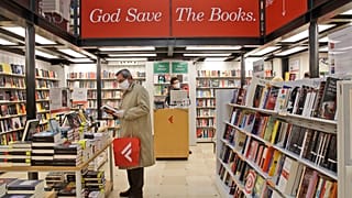 Un hombre ojea un volumen en una librería de Roma