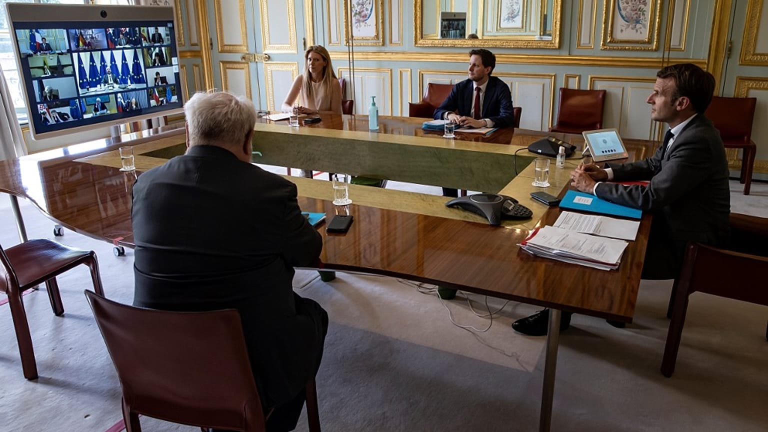 French President Emmanuel Macron (R) attends the video conference