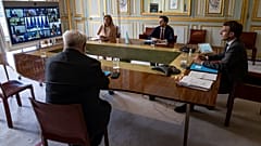 French President Emmanuel Macron (R) attends the video conference