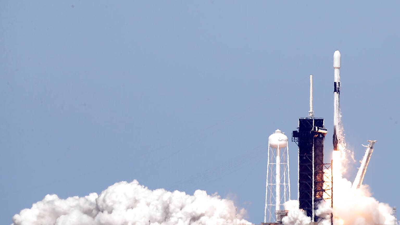 A Falcon 9 rocket with approximately 60 satellites for SpaceX's Starlink broadband network, lifts off from Kennedy Space Center in Cape Canaveral