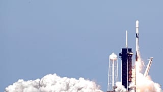 A Falcon 9 rocket with approximately 60 satellites for SpaceX's Starlink broadband network, lifts off from Kennedy Space Center in Cape Canaveral