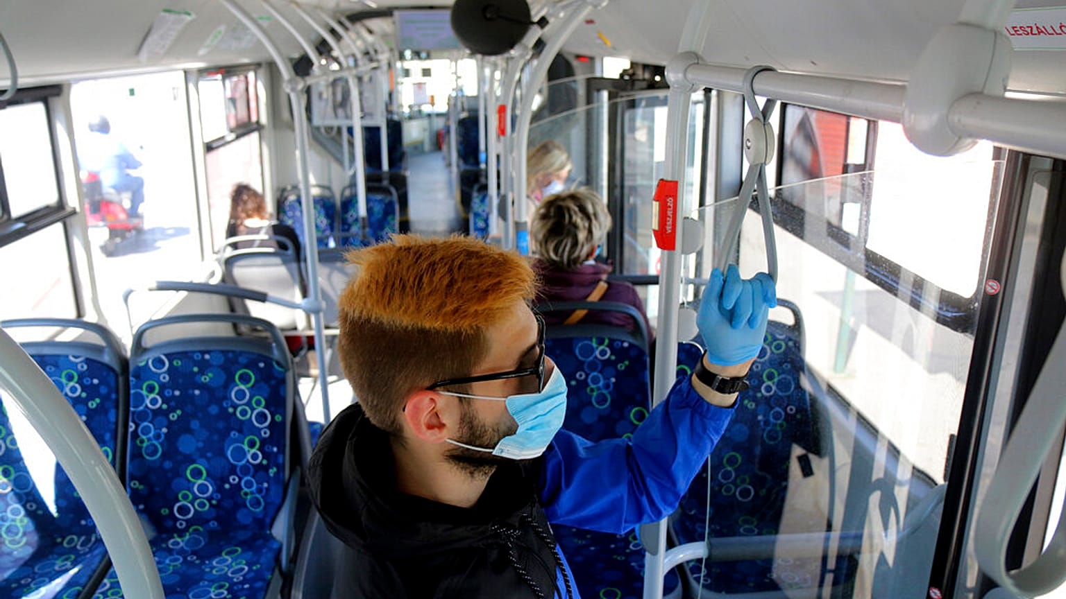 A man uses facial mask and gloves while riding on a public bus as a preventive measure against the coronavirus in Miskolc, Hungary, April 23, 2020