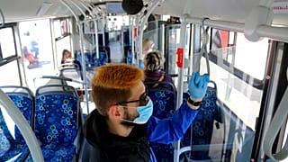 A man uses facial mask and gloves while riding on a public bus as a preventive measure against the coronavirus in Miskolc, Hungary, April 23, 2020
