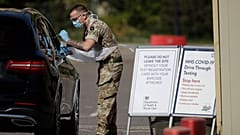 A soldier gives does a COVID-19 test at a drive-through testing centre at Chessington World of Adventures, Greater London