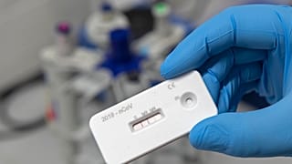 A scientist presents an antibody test to use with a blood sample for the coronavirus at a laboratory of the Leibniz Institute of Photonic Technology, Germany.
