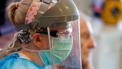 A nurse wears protective gear at Wren Hall nursing home in the central England village of Selston. 
