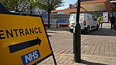 A security guard and a contractor at the gates of Manchester Central Convention Complex, converted into the "Nightingale Hospital North West", on April 13, 2020