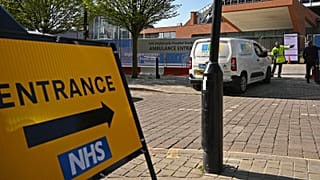 A security guard and a contractor at the gates of Manchester Central Convention Complex, converted into the "Nightingale Hospital North West", on April 13, 2020