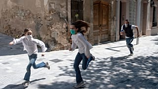 طفلان يركضان في شوارع برشلونة أمس الأحد بعدما سمحت السلطات للأطفال بالخروج لمدة زمنية محددة 