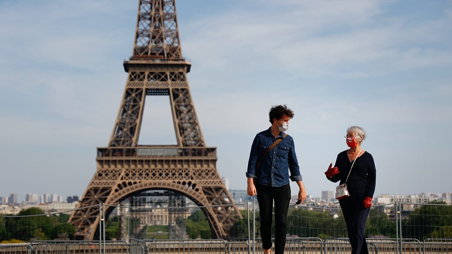 Paris'in Trocadero meydanında koronavirüsten korunmak için maske takmış iki kişi yürüyor