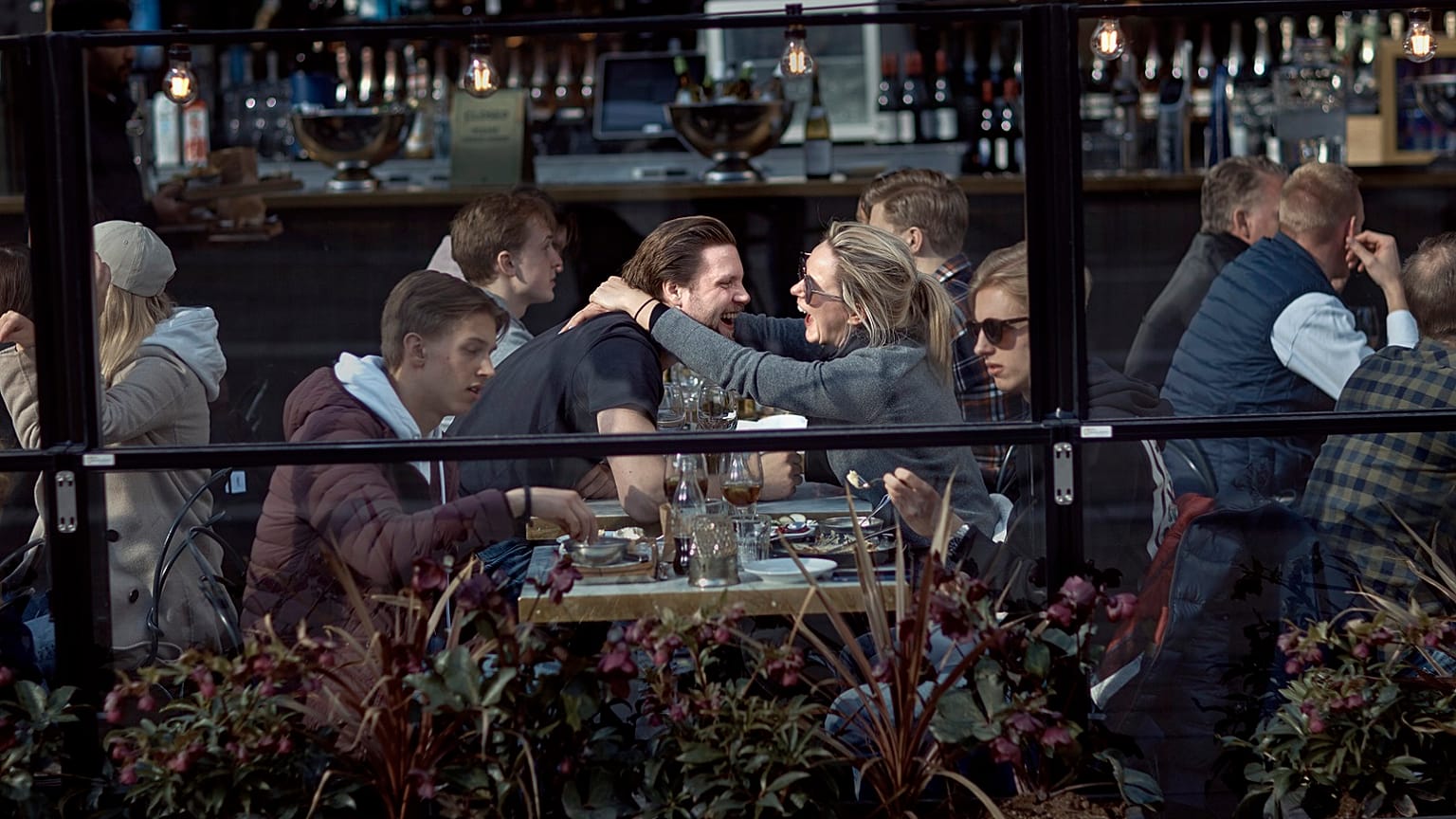 A couple hug and laugh as they have lunch in a restaurant in Stockholm, Sweden, Saturday, April 4, 2020