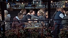 A couple hug and laugh as they have lunch in a restaurant in Stockholm, Sweden, Saturday, April 4, 2020