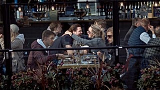 A couple hug and laugh as they have lunch in a restaurant in Stockholm, Sweden, Saturday, April 4, 2020