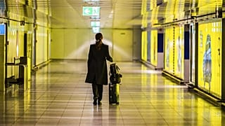Eine Reisende schiebt ihren Koffer durch einen leeren Gang am Frankfurter Flughafen, 12. März 2020.
