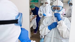 Medical workers put on protective gear in order to assist coronavirus patients at the intensive care unit of Vinogradov City Clinical Hospital in Moscow, Russia. 