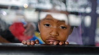 ABD yaptırımlarına hedef olan Venezuela'nın başkenti Karakas'ta otobüsten dışarı bakan bir kız çocuğu