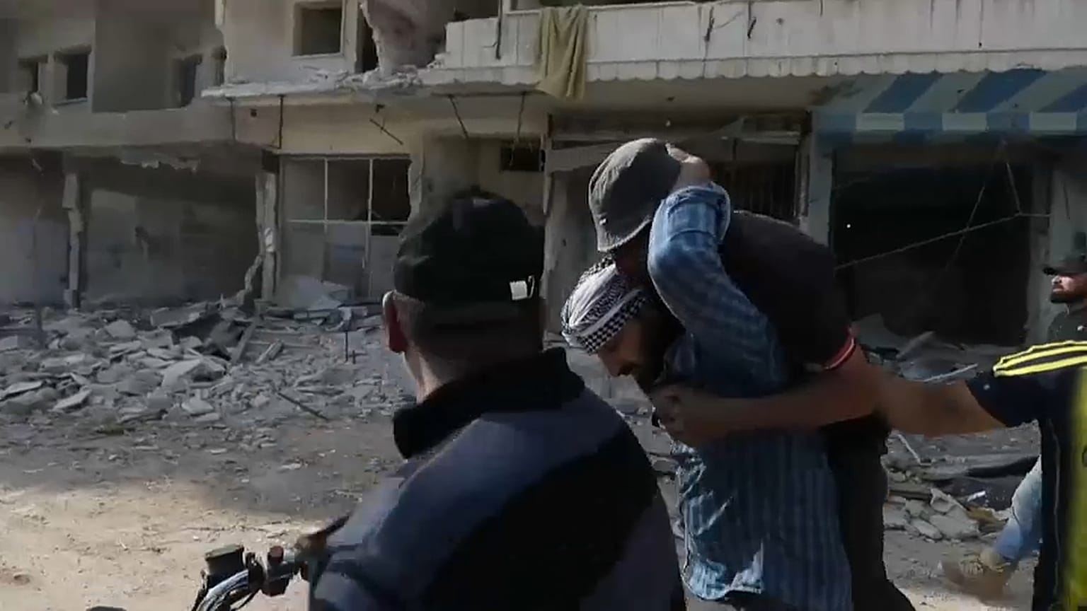 متظاهر يحمل جريحا سقط برصاص جبهة النصرة في معرة النعمان يوم الجمعة 01.05.2020 
