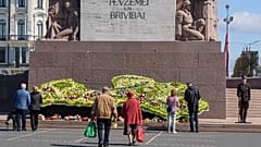 People arrive to lay a wreath in front of the Monument of Freedom to mark the 30th anniversary of the restoration of independence of the Republic of Latvia on May 4, 2020