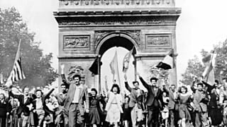 Parisians march through the Arc de Triomphe jubilantly waving flags of the Allied Nations as they celebrate the end of World War II on May 8, 1945.  