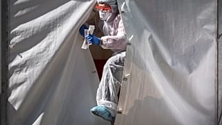 A medical staff gets out from a tent of a testing point for the COVID-19 coronavirus in central Moscow 